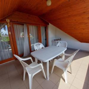 una mesa blanca y sillas blancas en el porche en Saci Lak, en Gyenesdiás