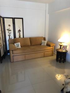 Sofá marrón en una sala de estar con 2 mesas en AlbaTigre en Tigre