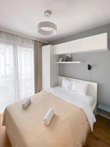 a bedroom with a large white bed with two pillows at Like Home Apartments in Kraków