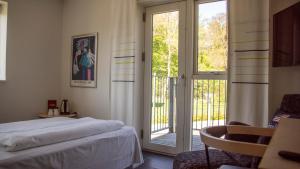 1 dormitorio con 1 cama y puerta corredera de cristal en Hotel Strandtangen en Skive