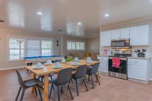 a kitchen with a ping pong table and chairs at Texas Vacation Home, Game Room & Pool By Sixflags in San Antonio