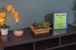 una mesa con flores y un cartel de bienvenida. en Beautiful Apartment At The Botanical Gardens #1 en San Antonio