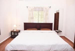 Un dormitorio blanco con una cama grande y una ventana en 4BHK Private Pool villa in North Goa and Kayaking nearby!!, en Moira