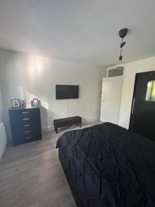a bedroom with a bed and a flat screen tv at 1-bed apartment w/ electric fireplace in London