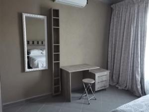 a bedroom with a desk and a mirror and a bed at Clerhatha Guesthouse in Acornhoek +10 photos