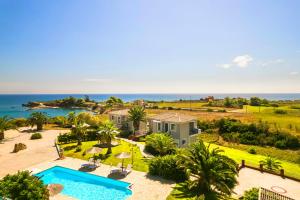 an aerial view of a house with a swimming pool and the ocean at Villa Sapphire in Kounopetra