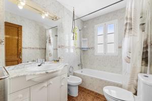 ein Badezimmer mit Waschbecken, Toilette und Badewanne in der Unterkunft Casa Merlin in Playa Honda