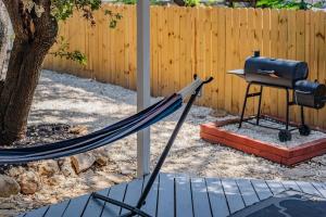 a hammock and a grill in a backyard at Beautiful Home With Sunroom, Gameroom, Yard & Bbq in San Antonio