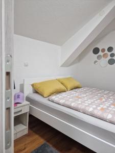 a bedroom with a bed with a yellow pillow at Apartments Gradiska in Bosanska Gradiška
