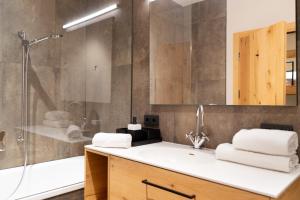 a bathroom with a shower and a sink and a tub at Heimat 1495m Appartement TYP 3 in Schröcken