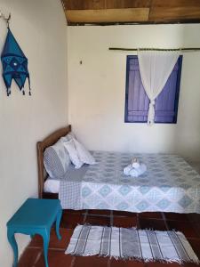 a small bedroom with a bed and a window at Chalé Flor do Ser in Canoa Quebrada