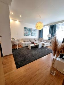 a living room with white furniture and a large window at Apartment Banska - City Centre & Free Parking in Banská Bystrica