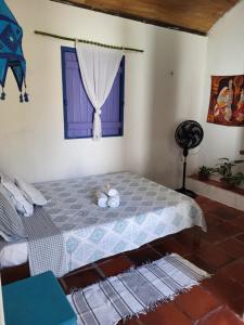 a bedroom with a bed with a window at Chalé Flor do Ser in Canoa Quebrada