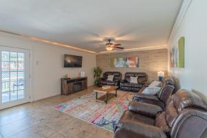 a living room with a leather couch and a table at Luxury 5br House With Pool By Seaworld & Lackland in San Antonio
