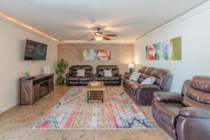 ein Wohnzimmer mit Ledermöbeln und einem Deckenventilator in der Unterkunft Luxury 5br House With Pool By Seaworld & Lackland in San Antonio