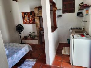 a small kitchen with a refrigerator in a room at Chalé Flor do Ser in Canoa Quebrada +37 photos