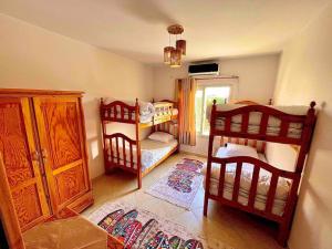 um quarto com 2 beliches e uma janela em 5-BRS Villa Steps from Beach Cozy vibes em Ain Sokhna