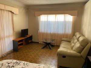 sala de estar con sofá y TV en Aspley bedroom & share bathroom with other guests, en Brisbane