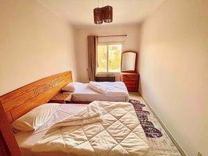 - une chambre avec 2 lits et une fenêtre dans l'établissement 5-BRS Villa Steps from Beach Cozy vibes, à Ain Sokhna