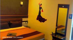Dormitorio con cama con pegatina de mujer en la pared en MSP Grands Inn, en Madurai