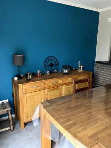 a room with a wooden table and a blue wall at Maison avec jardin 