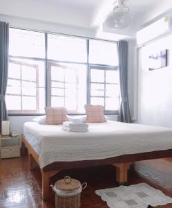 a bedroom with a large bed in front of windows at Wayside Guesthouse in Chiang Mai