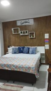 ein Schlafzimmer mit einem großen Bett mit blauen Kissen in der Unterkunft Kit Nets D+ in Baixio