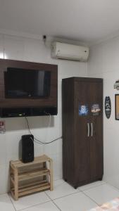 ein Wohnzimmer mit einem Schrank und einem TV an der Wand in der Unterkunft Kit Nets D+ in Baixio