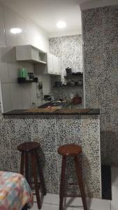eine Küche mit zwei Hockern und einer Arbeitsplatte in der Unterkunft Kit Nets D+ in Baixio