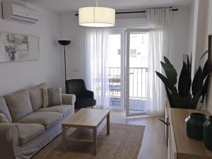a living room with a couch and a table at Spacious Front Line Beach 3 Bedroom apartment with amazing sea views a few steps from the beach in Benalmádena