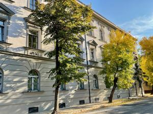 a white building with two trees in front of it at Magnolia Sunshine in Budapest