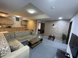 uma sala de estar com um sofá e uma mesa em Skylight apartments em Amã