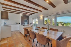 a kitchen and dining room with a wooden table and chairs at Villa Pura Vida in Denia