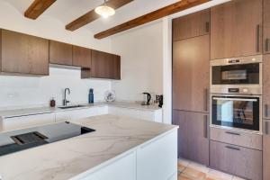 a kitchen with white counter tops and wooden cabinets at Villa Pura Vida in Denia