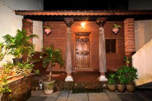 a brick house with a wooden door and some plants at Villa D Jems -A Heritage Home stay in Puducherry