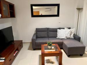 a living room with a couch and a table at Two bedroom Apt., Hacienda Riquelme Golf Resort in Murcia