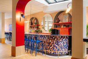 a bar in a restaurant with blue stools at City Hotel Groningen in Groningen