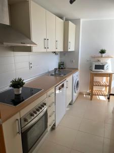 a kitchen with a sink and a dishwasher at Two bedroom Apt., Hacienda Riquelme Golf Resort in Murcia