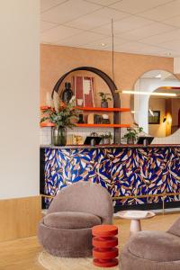 a living room with a chair and a mirror at City Hotel Groningen in Groningen