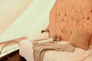 een bed in een tent met een deken erop bij Smuk Grutte Bell Tent in Echtenerbrug