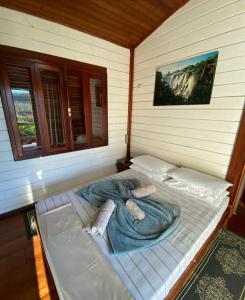- un grand lit dans l'angle de la chambre dans l'établissement Pousada Arara Canindé, à Sao Jorge