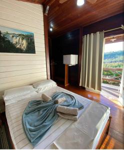 a large bed in a room with a large window at Pousada Arara Canindé in Sao Jorge
