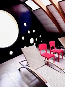 サンティアゴにあるabba Presidente Suites Santiagoの椅子2脚、テーブル1台、赤い椅子2脚が備わる客室です。