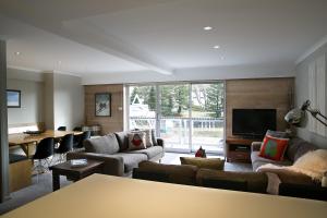 Altitude Apartments في فولز كريك: غرفة معيشة مع كنب وتلفزيون