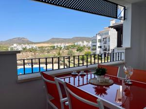 a balcony with a table and a view of a pool at Two bedroom Apt., Hacienda Riquelme Golf Resort in Murcia