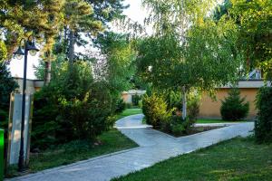 un chemin de jardin avec des arbres et une lumière de rue dans l'établissement Club Dunarea, à Eforie Nord