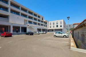 a parking lot with cars parked in front of a building at DOMINIUM CITY SUITES in Dubrovnik