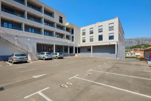 a parking lot with cars parked in front of a building at DOMINIUM CITY SUITES in Dubrovnik