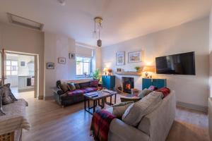 a living room with two couches and a tv at Little Apple- Free Parking, Hot tub, Fire, Town Centre in Appleby
