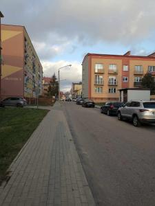 a street with cars parked on the side of the road at Apartament Słoneczny Olecko Centrum in Olecko
